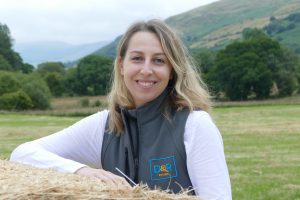 Abi Wass leaning on bale of hay