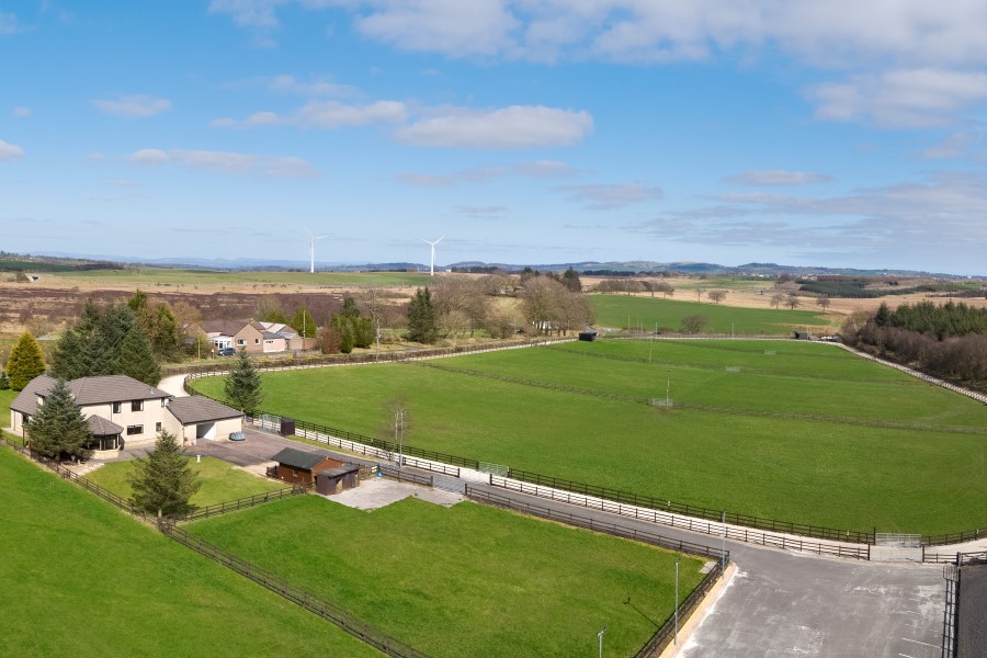 Aerial shot of a paddock with a house in the foreground